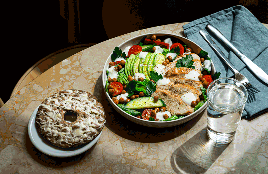 En kycklingsallad med knäckebröd och ett glas vatten